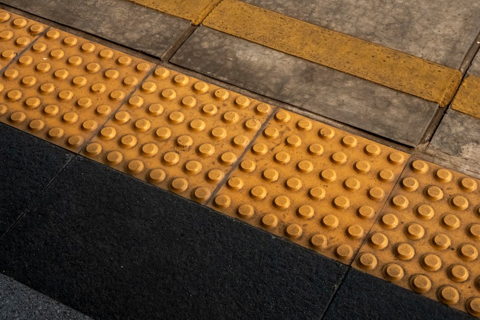 Interior view of Crofton Park Station platform showing a modern, stainless steel train arriving or departing. The platform features polished dark stone flooring with a yellow tactile warning strip alo